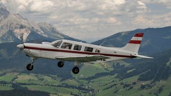 Aerial view of the Alpenflug sightseeing airplane Piper-Saratoga in front of the impressive mountain scenery | © Dietmar Schreiber 
